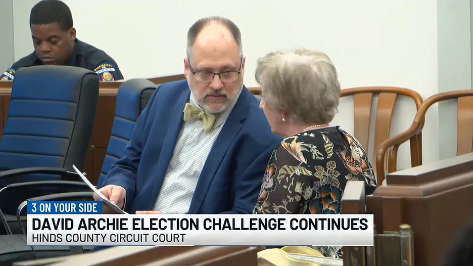 News still: Matt Wilson conferring with a colleague in the Hinds County courtroom, WLBT, March 27, 2026